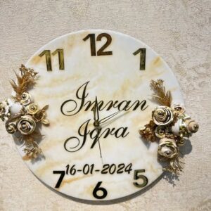 Personalized floral wall clock with custom names and date, featuring gold floral design and marble finish.